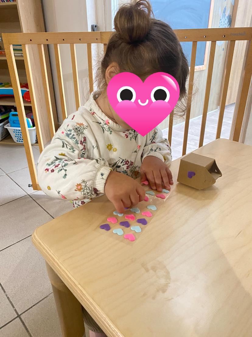 Enfant collant des gommettes lors d'une activité manuelle