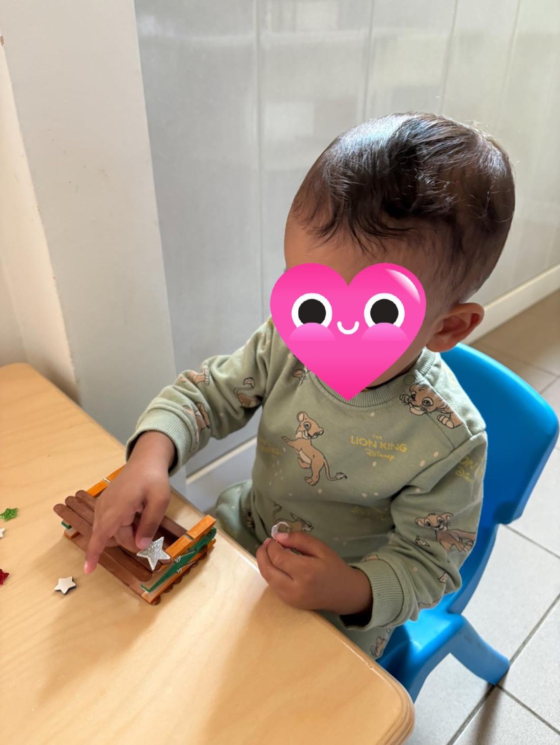 Bricolage d'une maisonnette en bâtonnets, activité manuelle chez l'assistante maternelle