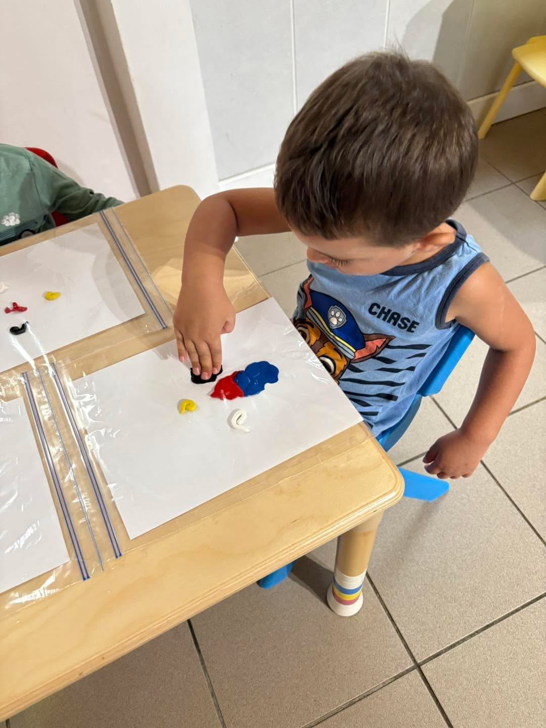 Enfant manipulant de la pâte à modeler pour une activité d'éveil sensoriel