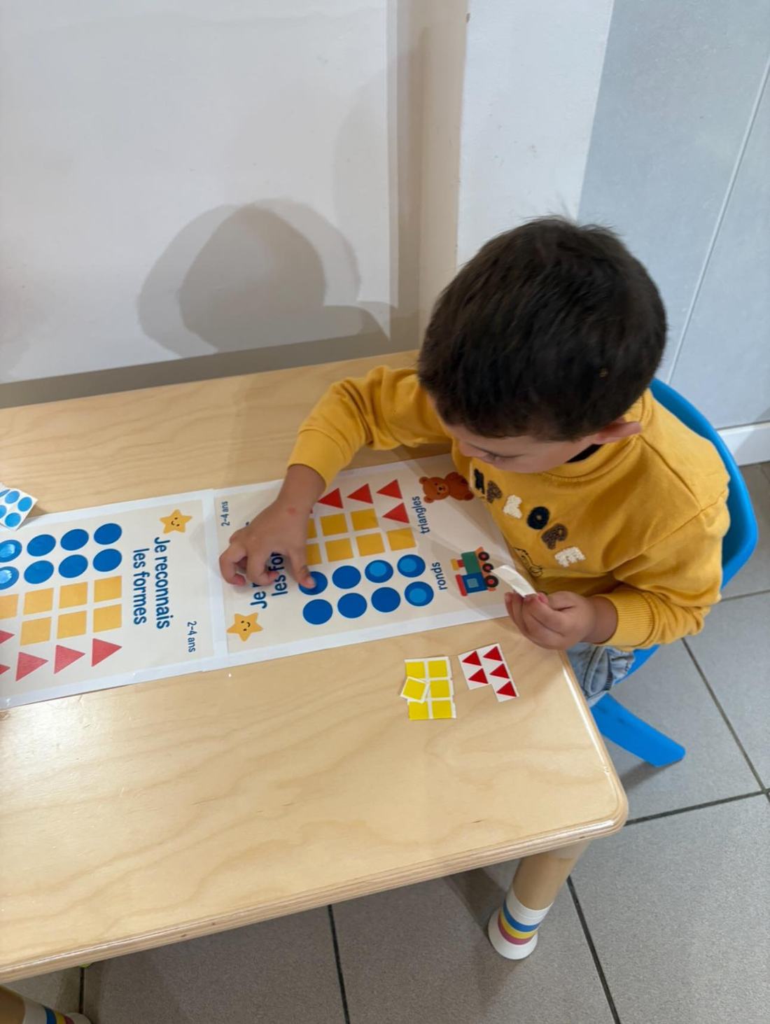 Enfant apprenant à reconnaître les formes géométriques lors d'une activité éducative